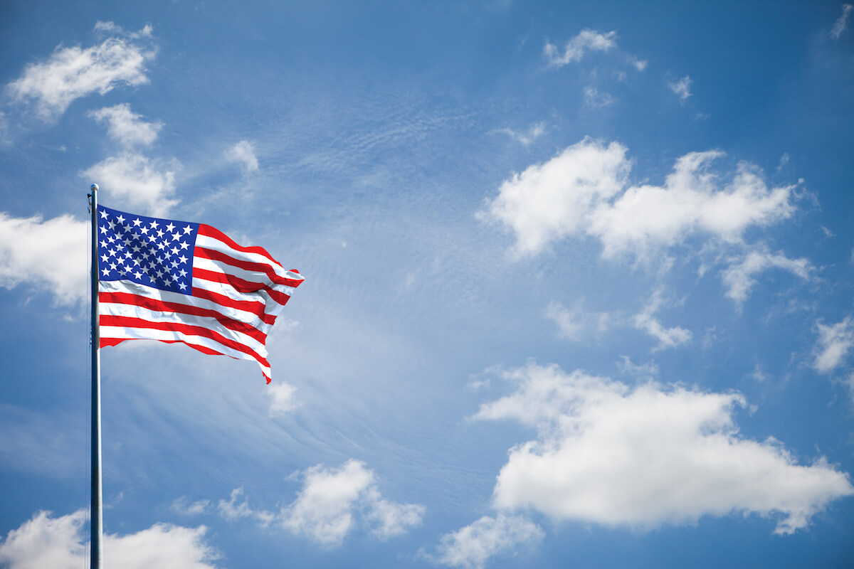 American flag blowing in blue sky
